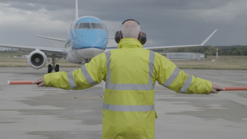 A man directing a plane on a runway