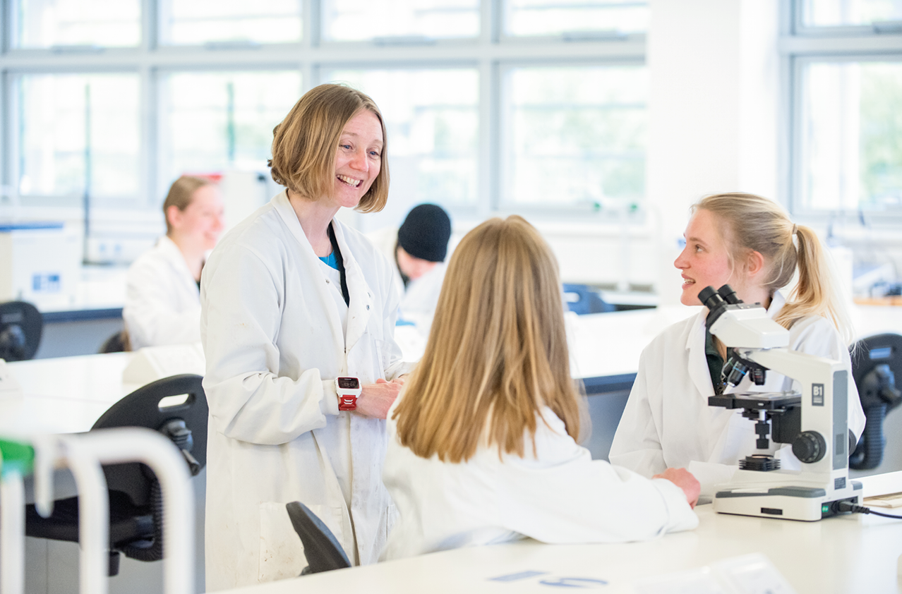 Students and a lecturer in a laboratory Students and a lecturer in a laboratory